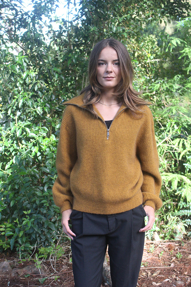 Gold woman's quarter-zip Merino Possum jersey with rib detail. 